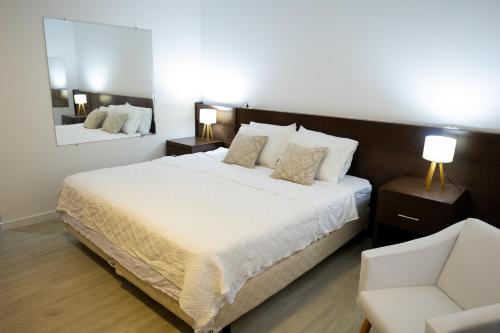 Edifício Flat Hotel Congonhas في ساو باولو: غرفة نوم بسرير كبير وكرسي