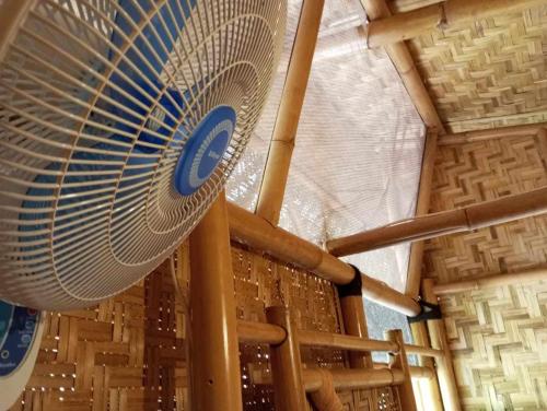 a large mechanical fan hanging from the ceiling of a building at Uncle Hippie's Dream in Gili Meno
