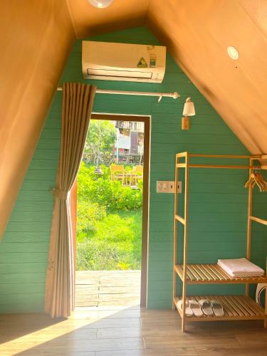 a room with a green wall with a bunk bed at Dứa Homestay in Bao Loc