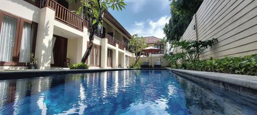 a swimming pool in front of a building at Sekuta Condo Suites in Sanur