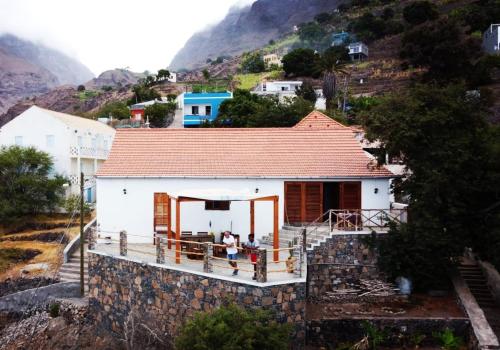 una casa en una colina con gente de pie en el porche en Kaza Ladera en Seladinha