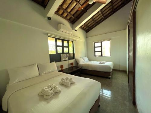 a bedroom with two beds with towels on them at Balay Pacifico in Sarog