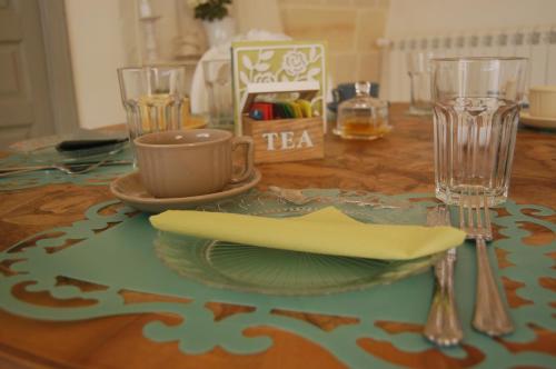 a table with a table cloth with a plate and a cup at Masseria Sorani in Manduria
