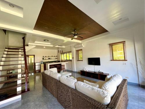 a large living room with couches and a tv at Balay Pacifico in Sarog