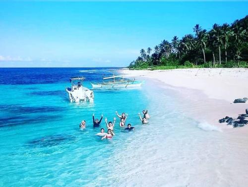 a group of people in the water on a beach at Balay Pacifico in Sarog