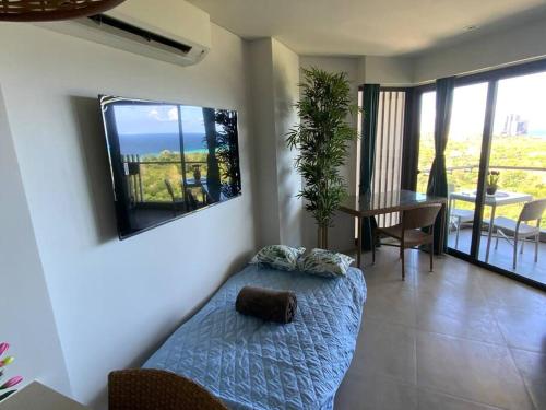 a bedroom with a bed and a dining room with a table at Ma Roberta - Tambuli Resort with fast Wifi 16 Floor Studio Type in Lapu Lapu City