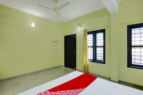 a bedroom with a bed and a black door at OYO Prasanth Holiday Inn in Chekadi