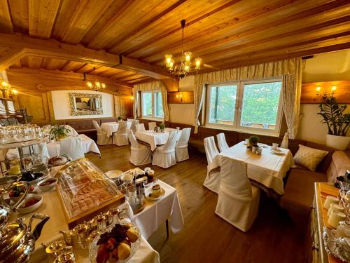 ein Esszimmer mit weißen Tischen und weißen Stühlen in der Unterkunft Panoramahotel Steirerland in Kitzeck im Sausal
