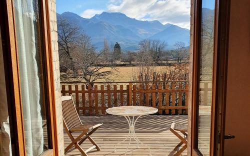 a patio with a table and chairs and a view of mountains at Le Vieux Tilleul in Seyne