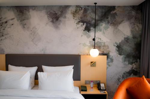 a bedroom with a bed and a painting on the wall at Novotel Jaipur Convention Centre in Jaipur