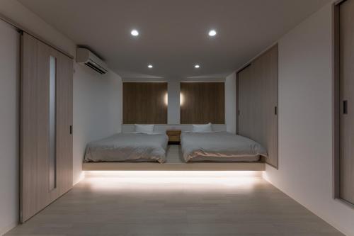 2 camas en un dormitorio con luces en el suelo en Okutsu Onsen Komeya Club, en Kagamino