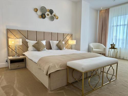 een slaapkamer met een groot bed en een stoel bij Hotel Queen Vera in Mamaia