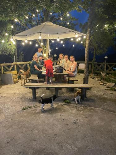 a group of people sitting at a picnic table with a dog at Pea homestay in Sa Pa