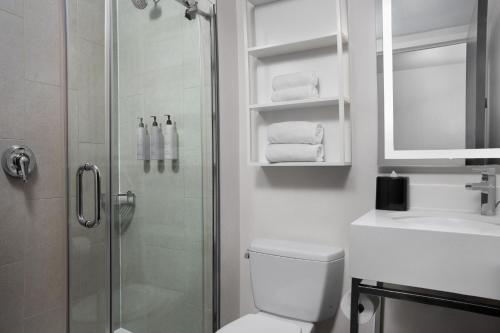La salle de bains est pourvue d'une douche, de toilettes et d'un lavabo. dans l'établissement Fairfield Inn & Suites by Marriott New York Manhattan/Central Park, à New York