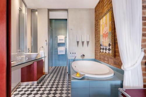 a bathroom with a tub and a sink at African Pride Melrose Arch, Autograph Collection in Johannesburg