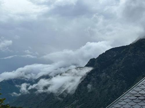 a view of a mountain with clouds in the valley at Ca de Mariona en Boí apartamento con terraza in Bohí