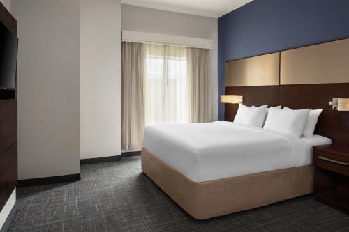 Residence Inn by Marriott Wheeling/St. Clairsville في سانت كليرسفيل: سرير أبيض كبير في غرفة الفندق