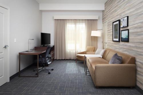 a hotel room with a couch and a desk and a computer at Residence Inn by Marriott Wheeling/St. Clairsville in Saint Clairsville