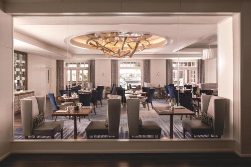 a dining room with tables and chairs and a chandelier at The Ritz-Carlton, Marina del Rey in Los Angeles