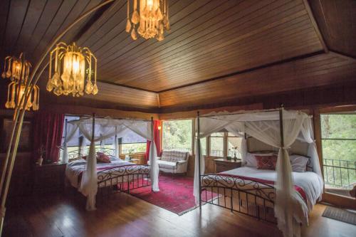1 dormitorio con 2 camas y techo de madera en Quiet Mind Lodge, Spa & Retreat Sequoias en Kernville