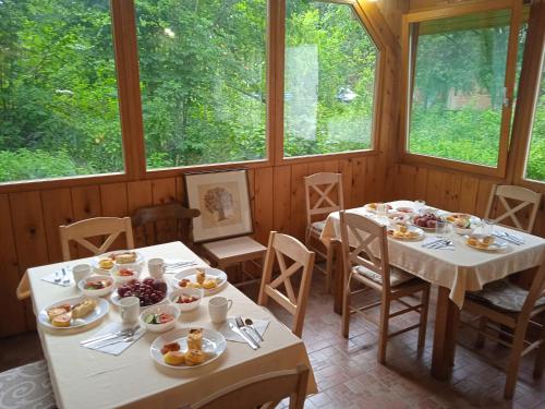 Sobe Zeravica Sremski Karlovci في سرمسكي كارلوفيتش: غرفة طعام مع طاولتين مع أطباق من الطعام