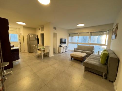 een woonkamer met een bank en een tafel bij SVW Apartment on the Beach in Netanya