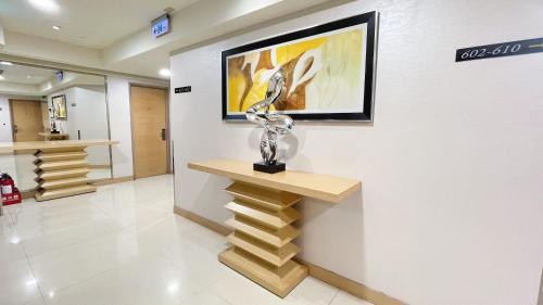 a art exhibit with a statue on a wall at Delton Hotel in Kaohsiung
