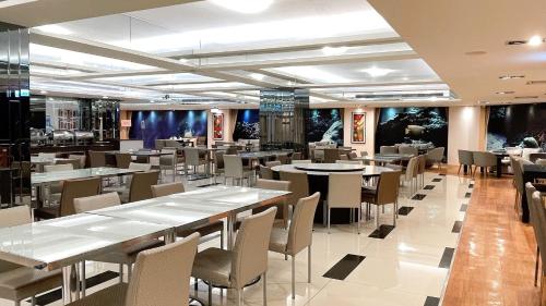 a dining room with tables and chairs in a restaurant at Delton Hotel in Kaohsiung