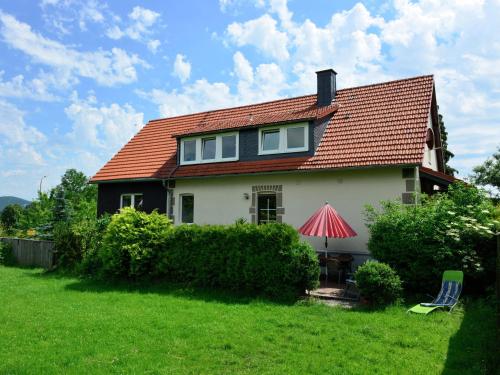 StormbruchにあるApartment in the Hochsauerland region in a quiet locationの赤い屋根と緑の芝生のある家