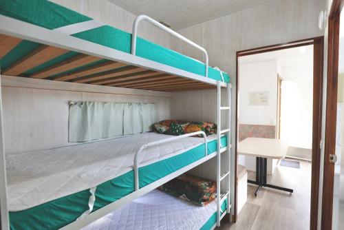 a bedroom with two bunk beds and a table at Sea Vu Caravan Park in Robe