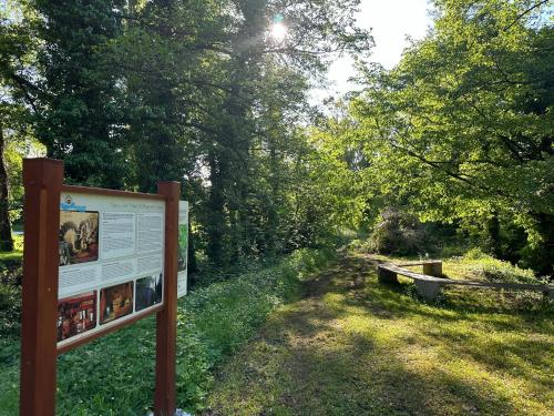 a sign in the grass next to a trail at Lavanderin Apartment in Dekani