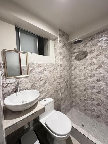 a bathroom with a white toilet and a sink at Departamento Amoblado in Huánuco