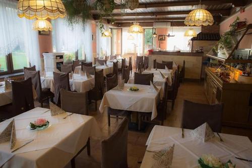 Canzolino的住宿－Albergo Aurora，餐厅配有桌椅和白色桌布