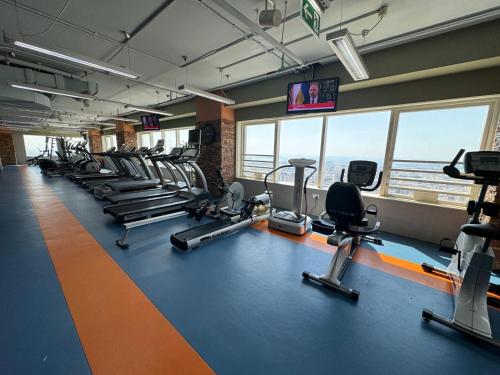 un gimnasio con una fila de cintas de correr y máquinas de cardio en 2 Bedroom Entire Furnished- Future Museum & Trade Center, en Dubái