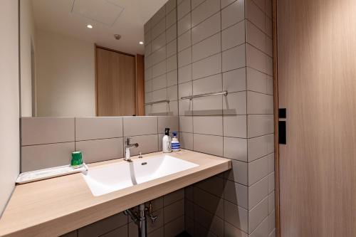 W łazience znajduje się umywalka i lustro. w obiekcie Oyado Seri w mieście Toyooka