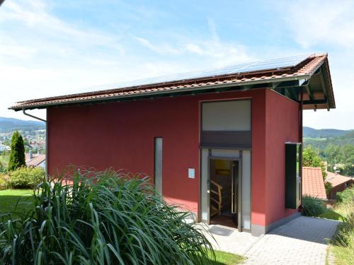 een rood huis met een grote glazen deur bij Tranquil Holiday Home in Blossersberg with Terrace in Viechtach