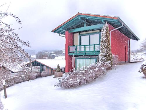 een rood huis met sneeuw op de grond bij Tranquil Holiday Home in Blossersberg with Terrace in Viechtach