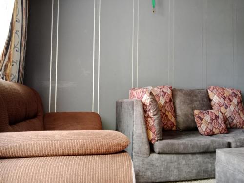 內羅畢的住宿－Drish Haven，客厅配有沙发和椅子