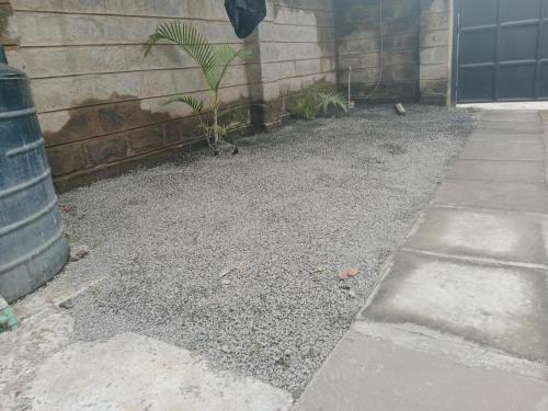 a gravel yard next to a building with a plant at Drish Haven in Nairobi