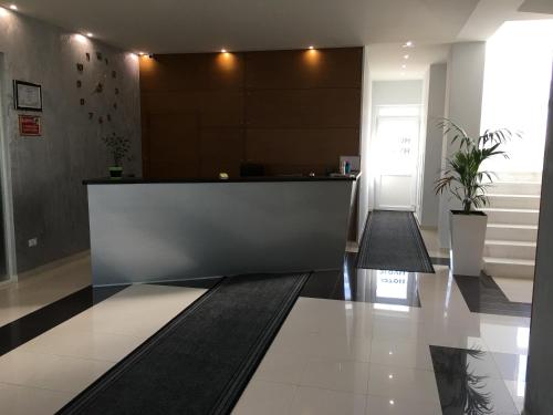 an office lobby with a reception counter and plants at Hotel Ascua in Tirana