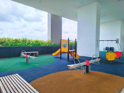 a play area with two swings and a playground at APPLE CloverLeafs Homestay Melaka in Melaka