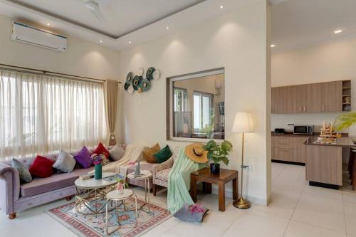 a living room with a couch and a table at Villa Hestia-3bed villa in Assagao By Masaya Stays in Verla