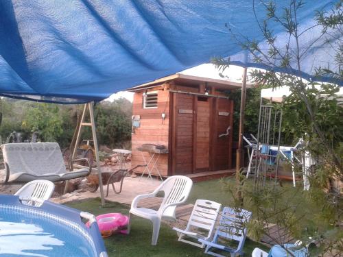 a yard with chairs and a house and a pool at Country lodging in Manot in Manot