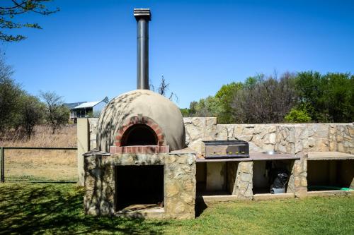 an outdoor pizza oven with a stone wall at 2916 on Egret - Parys Country and Golf Estate - Loadshedding friendly in Parys