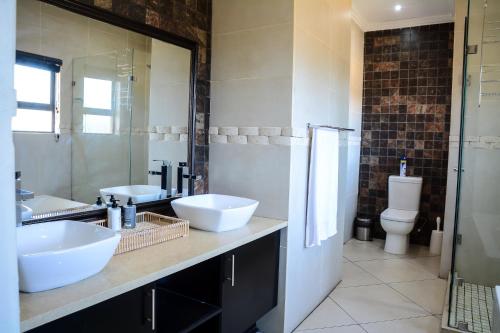 a bathroom with two sinks and a toilet at 2916 on Egret - Parys Country and Golf Estate - Loadshedding friendly in Parys