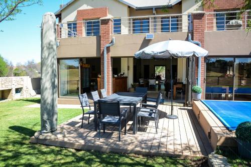 a patio with a table and chairs and a pool at 2916 on Egret - Parys Country and Golf Estate - Loadshedding friendly in Parys