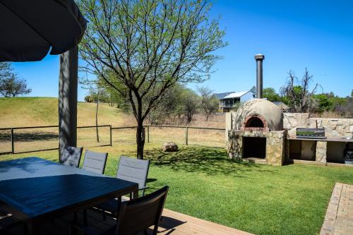 a patio with a table and chairs and an outdoor oven at 2916 on Egret - Parys Country and Golf Estate - Loadshedding friendly in Parys