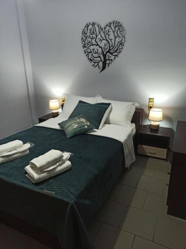 a bedroom with a bed with two towels on it at Fotini's Paradise in Platanidia