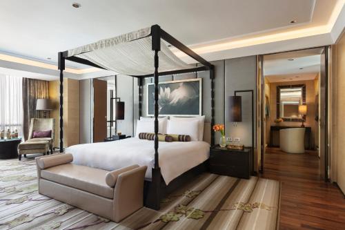 a bedroom with a large bed and a chair at Siam Kempinski Hotel Bangkok in Bangkok