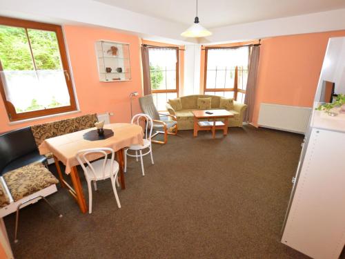 - un salon avec une table et des chaises dans l'établissement Snug Apartment in Jachymov near Ski area, à Jáchymov